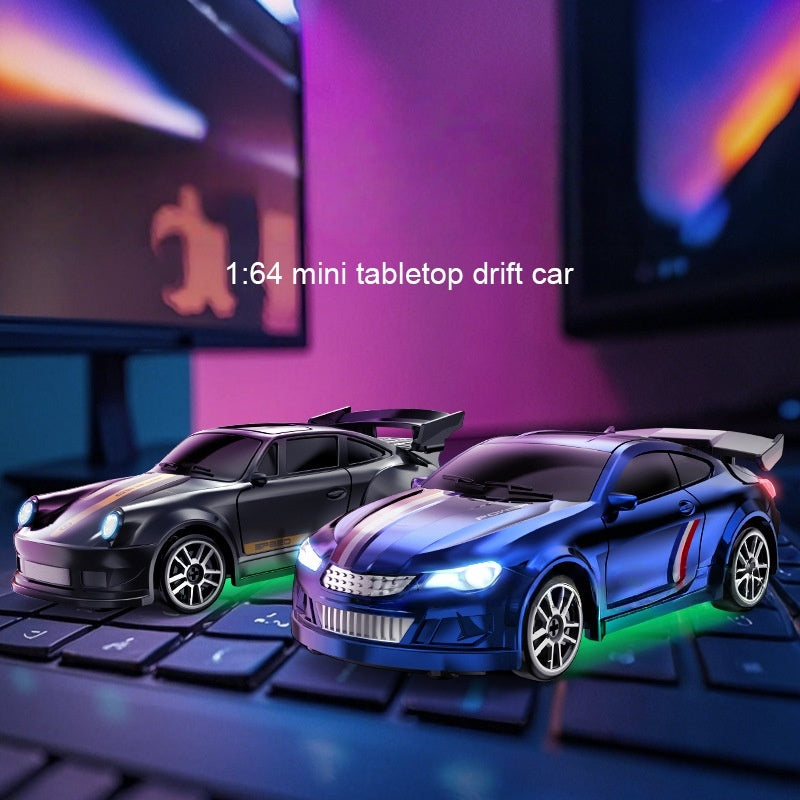 Two miniature drift cars on a keyboard with a blurred background